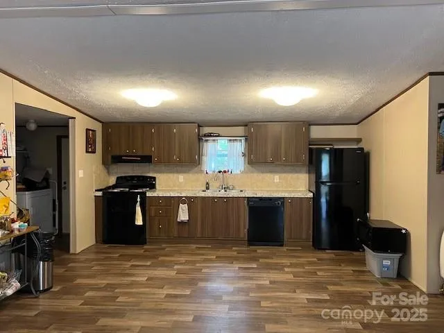 a large kitchen with a stove refrigerator and a sink