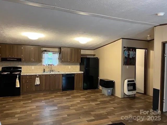 a large kitchen with stainless steel appliances granite countertop a refrigerator a stove and a sink