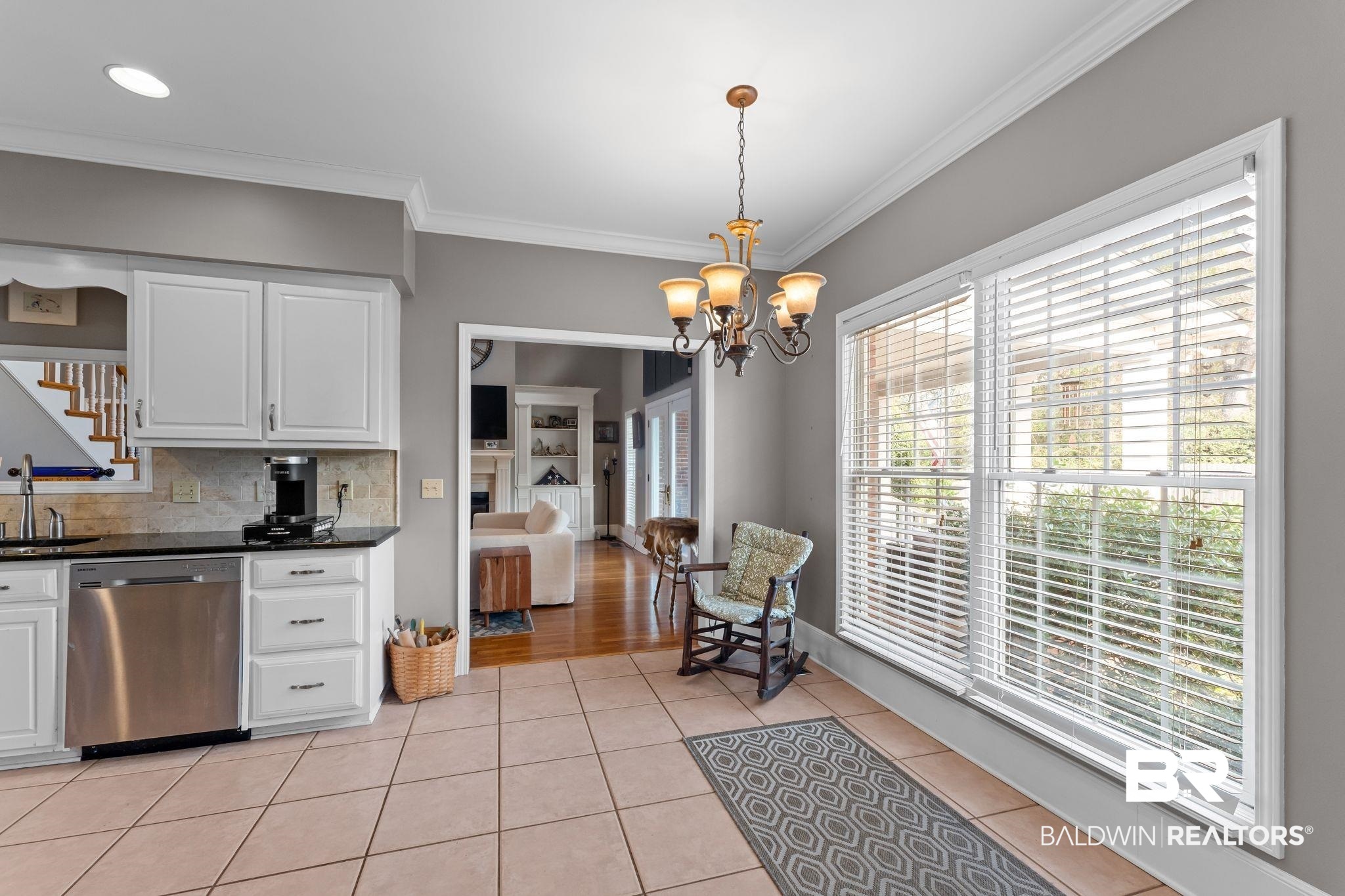 525 Norwood Road Monroeville, AL 36460 - Photo 15 of 55 Kitchen with white cabinetry, stainless steel dishwasher, light tile patterned floors, decorative backsplash, and crown molding