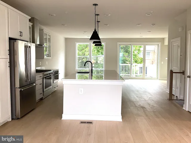 a kitchen with refrigerator a sink a stove and a center island