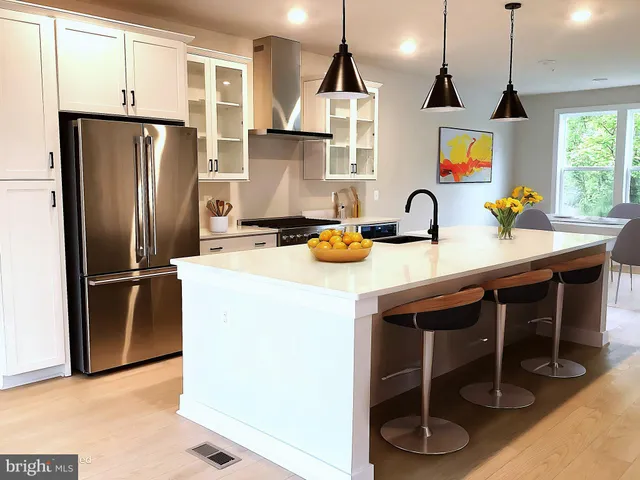 a view of a kitchen with kitchen island a sink stainless steel appliances and windows