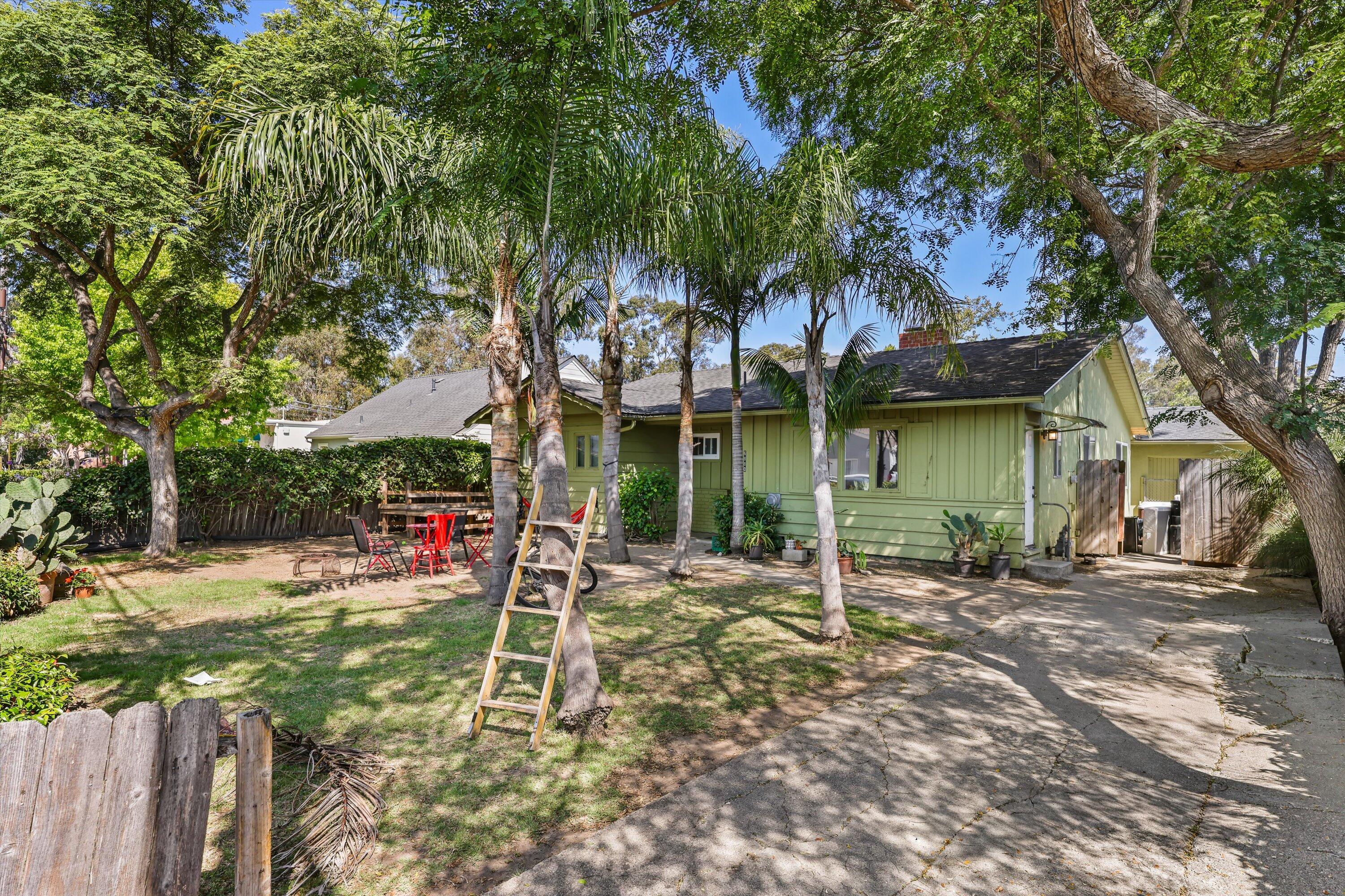 a view of a house with backyard and a tree