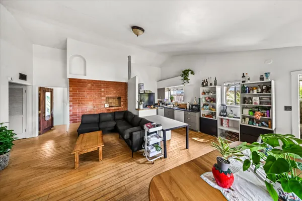a living room with furniture kitchen view and large window