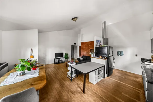 a living room with furniture a flat screen tv and a table