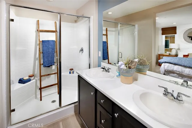a bathroom with a double vanity sink mirror and shower