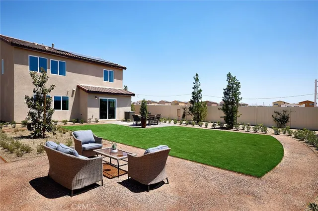 a view of a house with backyard sitting area and garden