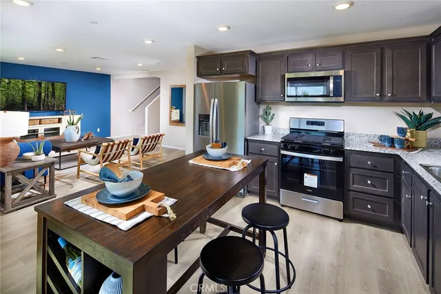 a kitchen with stainless steel appliances granite countertop a stove refrigerator and cabinets