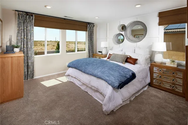 a bedroom with a bed and a dresser next to a window