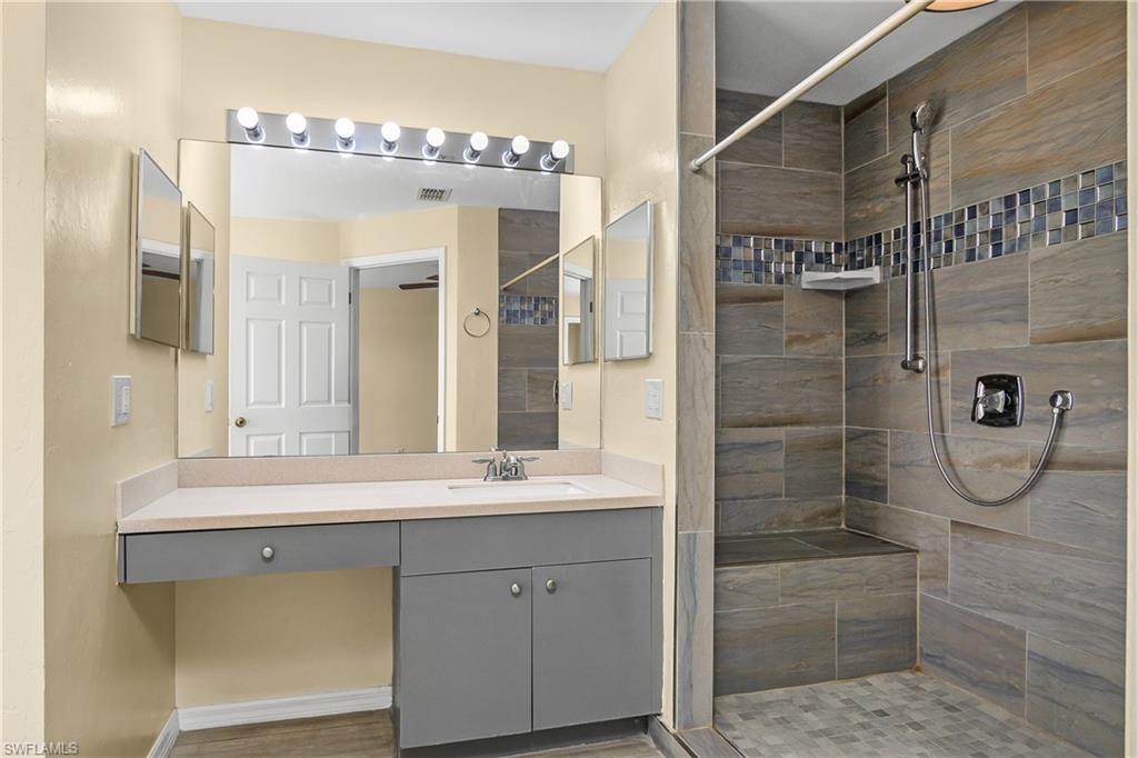 2905 Northeast 1st Place Cape Coral, FL 33909 - Photo 11 of 32 a bathroom with a double vanity sink mirror and shower