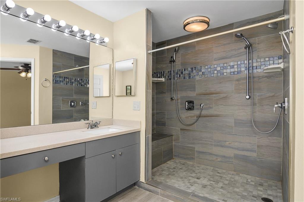 2905 Northeast 1st Place Cape Coral, FL 33909 - Photo 12 of 32 a bathroom with a double vanity sink mirror and shower