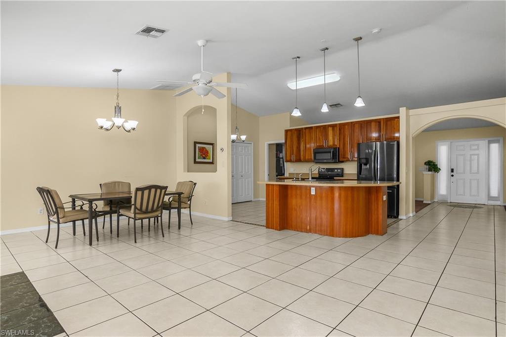 2905 Northeast 1st Place Cape Coral, FL 33909 - Photo 15 of 32 a view of a dining room kitchen with furniture and a chandelier