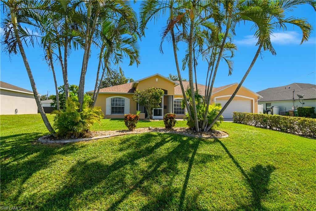 2905 Northeast 1st Place Cape Coral, FL 33909 - Photo 2 of 32 a front view of a house with yard and green space