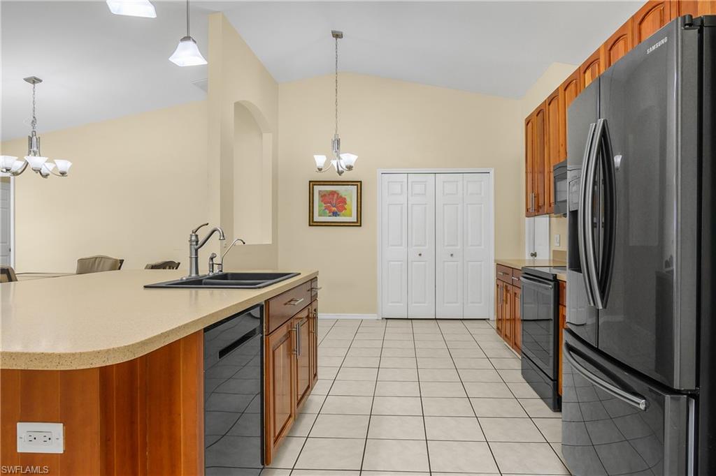 2905 Northeast 1st Place Cape Coral, FL 33909 - Photo 4 of 32 a kitchen with stainless steel appliances granite countertop a refrigerator a sink and a stove