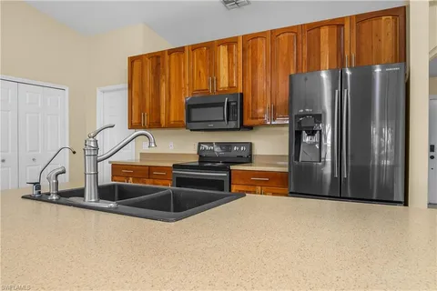 a kitchen with granite countertop a refrigerator and a sink