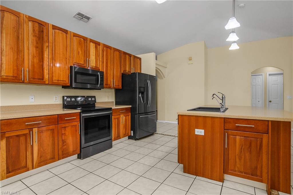2905 Northeast 1st Place Cape Coral, FL 33909 - Photo 6 of 32 a kitchen with stainless steel appliances granite countertop a refrigerator stove and sink