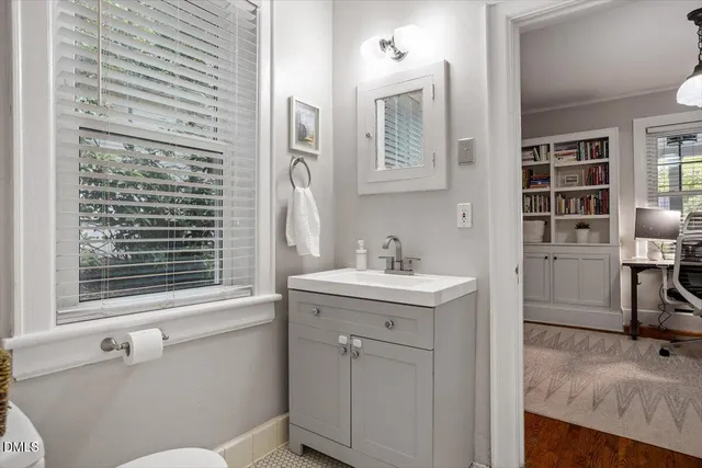 a bathroom with a sink a toilet and a window