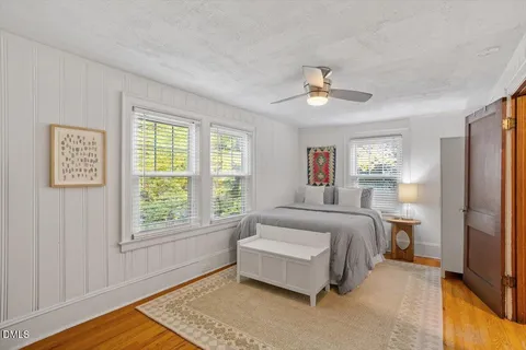 a spacious bedroom with a bed dresser and a window