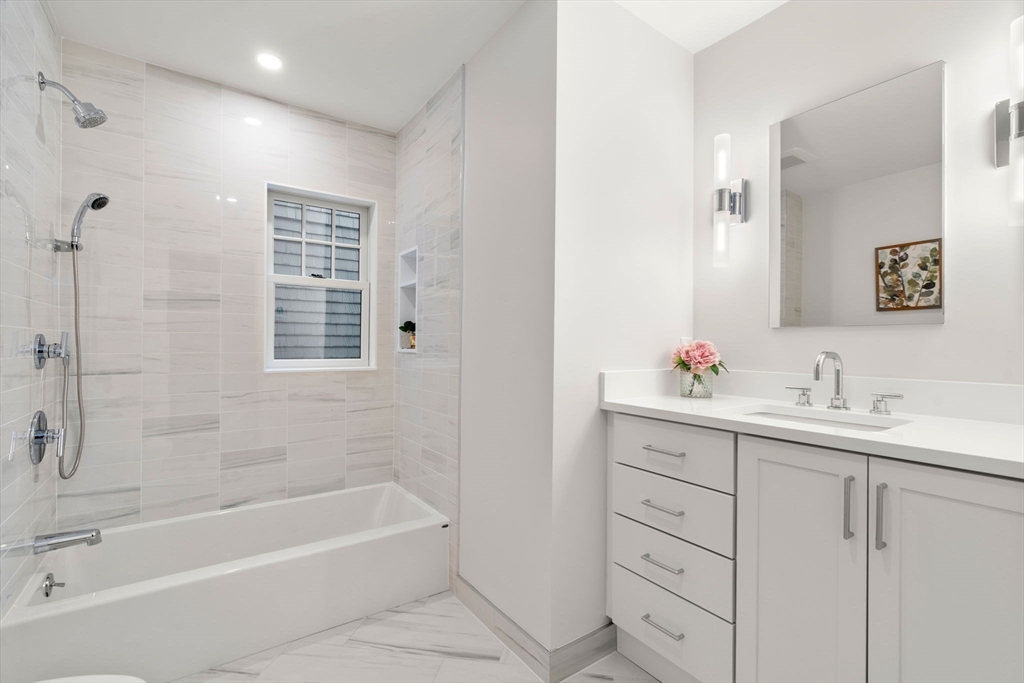63 Griggs Road Brookline, MA 02446 - Photo 17 of 20 a bathroom with a tub sink and mirror