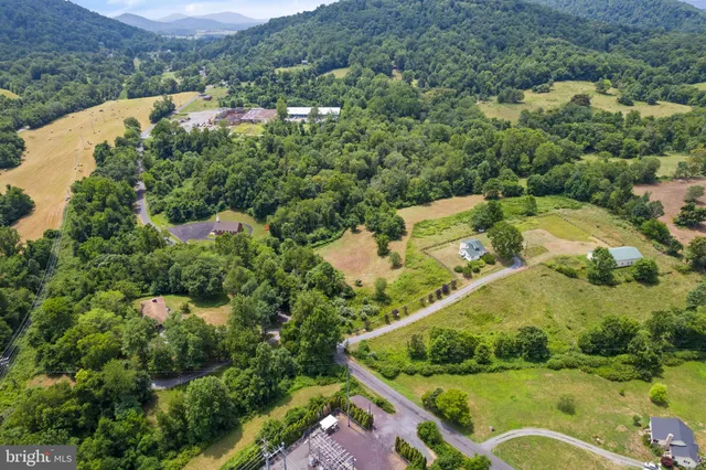 an aerial view of residential houses with outdoor space and trees