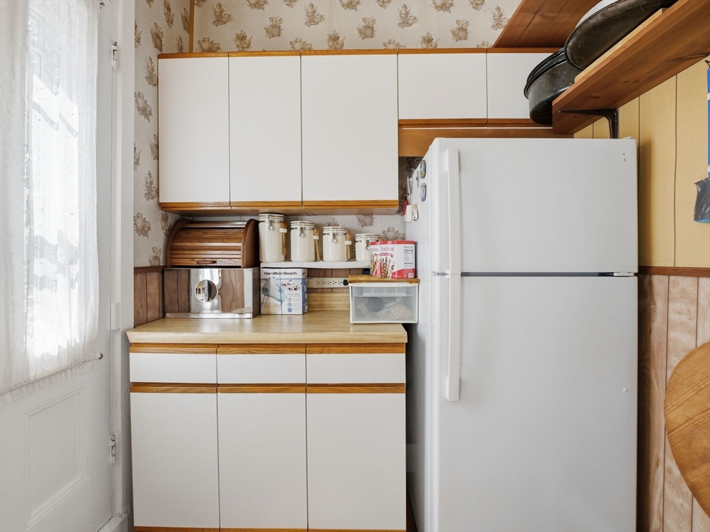 223 Stackpole Street Lowell, MA 01852 - Photo 26 of 42 a kitchen with refrigerator and cabinets