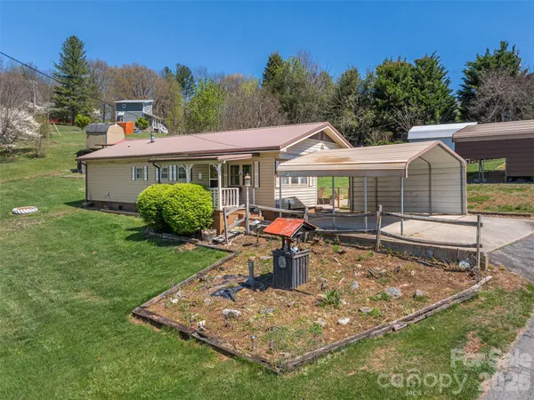 a view of a house with backyard sitting area and garden