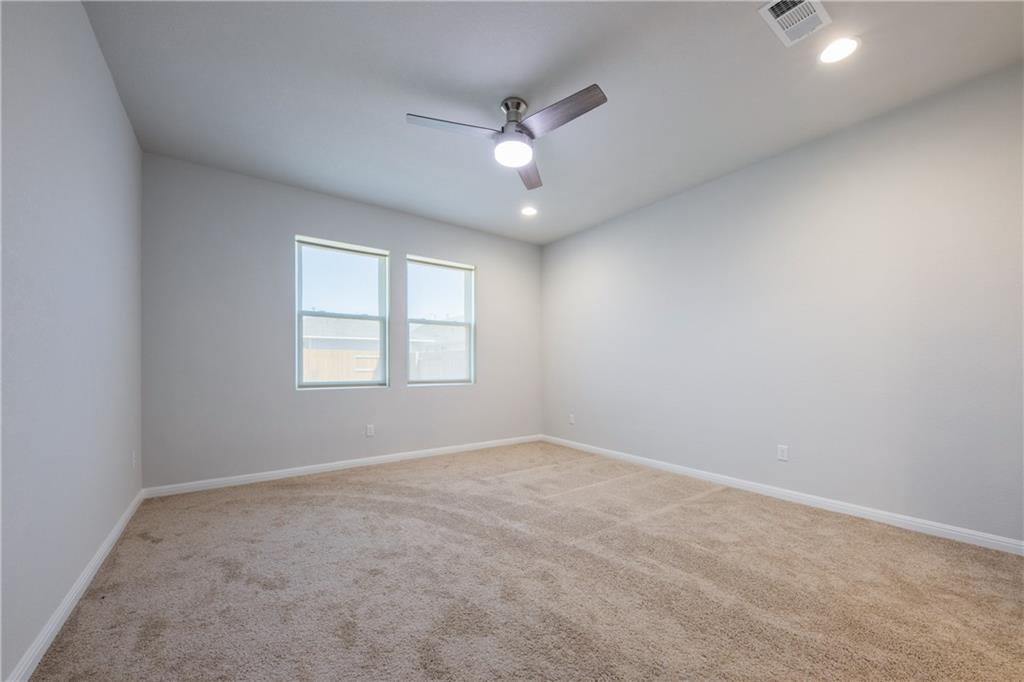 204 Cold Spg Loop Bastrop, TX 78602 - Photo 12 of 34 Carpeted interior space featuring two windows, a ceiling fan with light, and recessed lighting