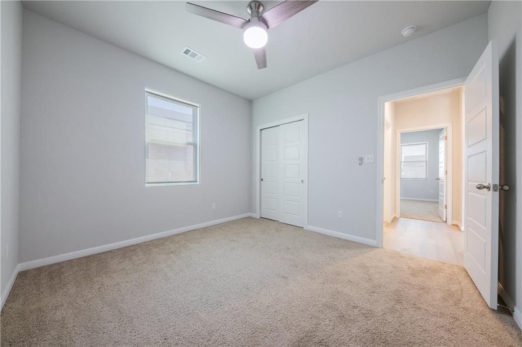 204 Cold Spg Loop Bastrop, TX 78602 - Photo 13 of 34 Carpeted room featuring a ceiling fan with integrated lighting, a window with blinds, and white bi-fold closet doors