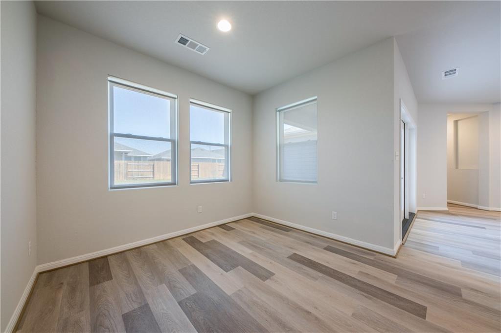 204 Cold Spg Loop Bastrop, TX 78602 - Photo 15 of 34 Spacious interior featuring wood-finish flooring, light neutral wall paint, and multiple windows