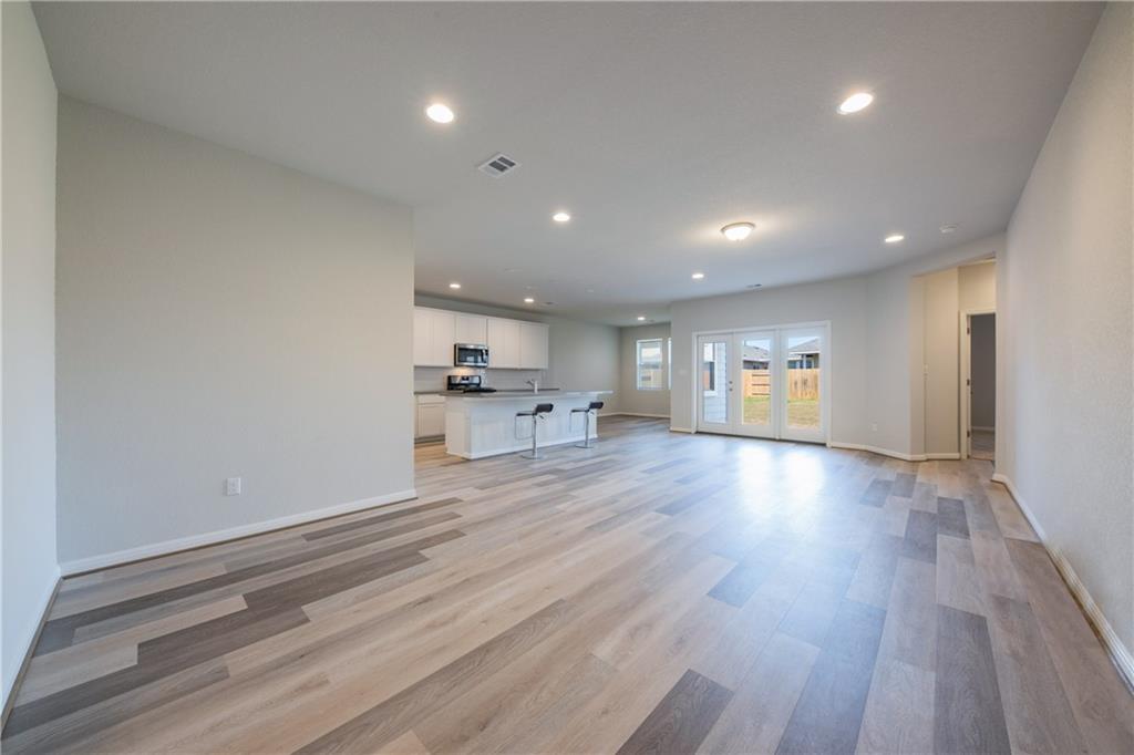 204 Cold Spg Loop Bastrop, TX 78602 - Photo 27 of 34 Spacious open-concept interior featuring wood-finish flooring, recessed lighting, and a modern kitchen with an island