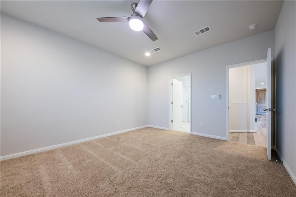 204 Cold Spg Loop Bastrop, TX 78602 - Photo 32 of 34 Spacious room featuring neutral carpeting, light gray walls, a ceiling fan with integrated lighting, and recessed ceiling lights