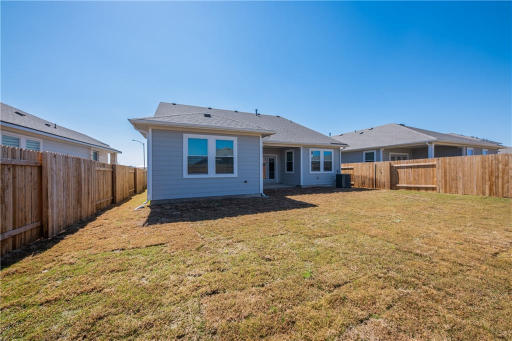 204 Cold Spg Loop Bastrop, TX 78602 - Photo 8 of 34 Spacious backyard featuring a sloped lawn and wooden privacy fencing