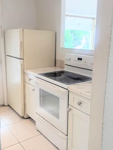 a kitchen with white cabinets and white appliances