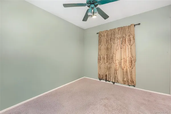 a view of a room with a window and a ceiling fan