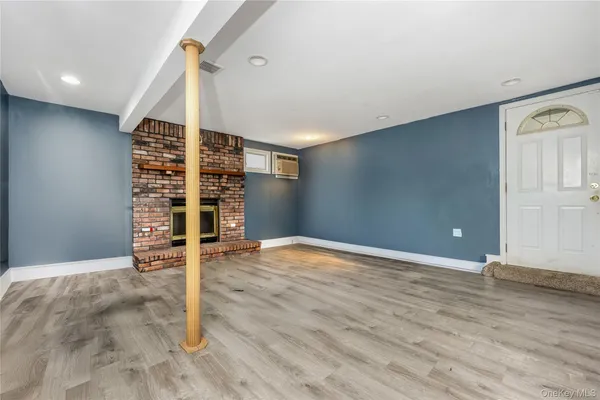 an empty room with wooden floor and entryway