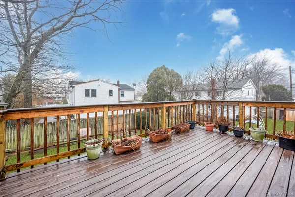 a balcony with wooden floor table and chairs