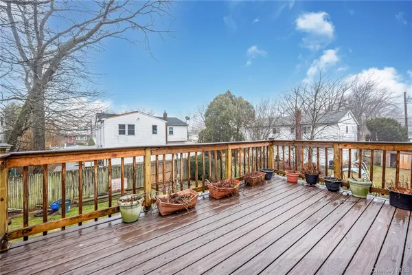 a balcony with wooden floor and outdoor seating