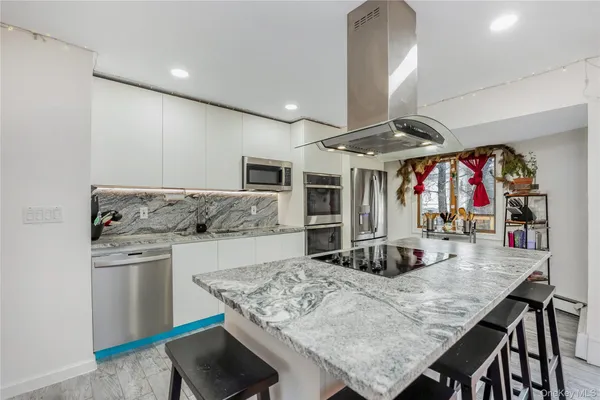 a kitchen with stainless steel appliances granite countertop a stove refrigerator and cabinets