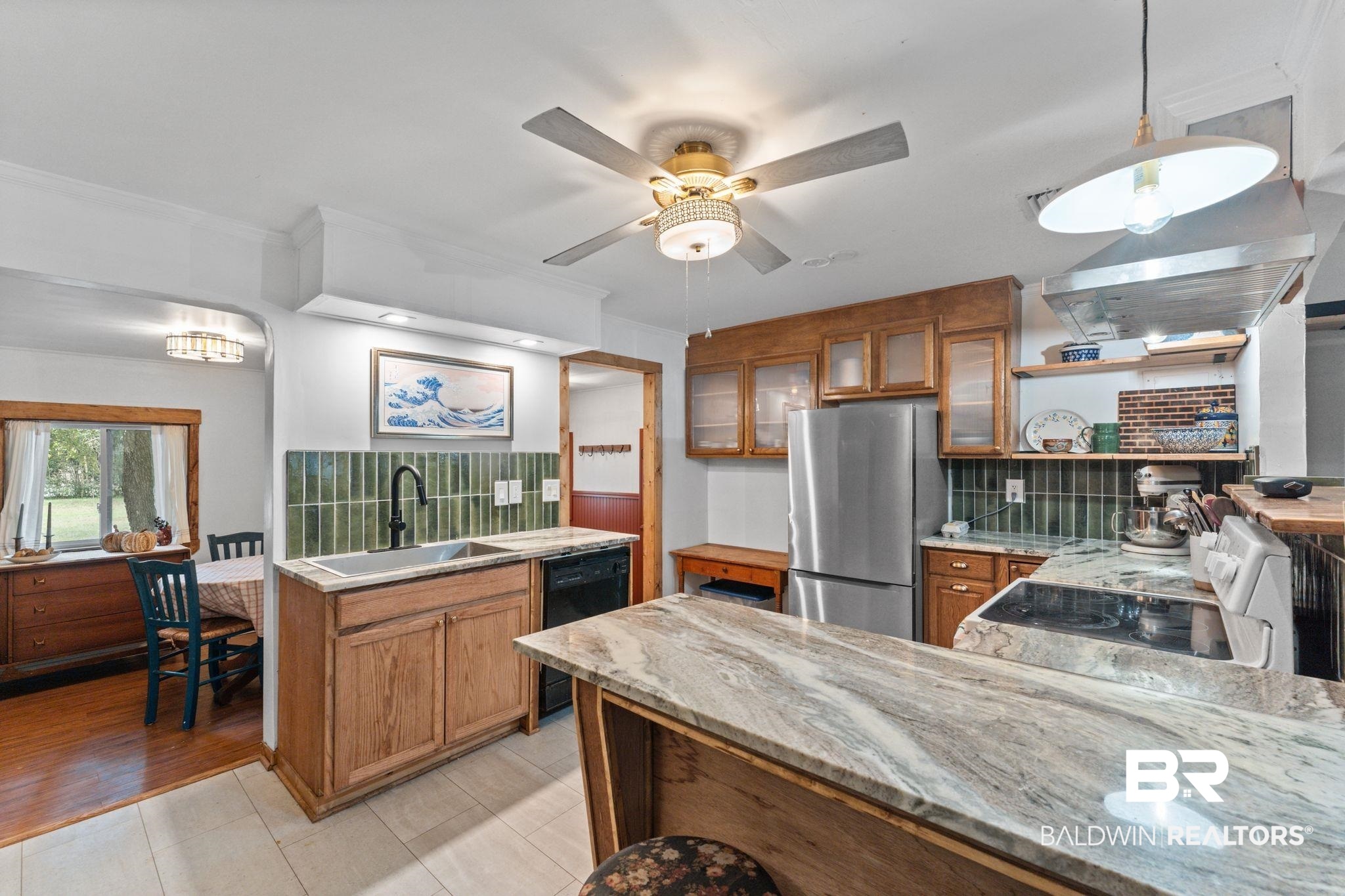 10785 Gregg Road Semmes, AL 36575 - Photo 3 of 35 Kitchen with brown cabinetry, freestanding refrigerator, backsplash, pendant lighting, and crown molding