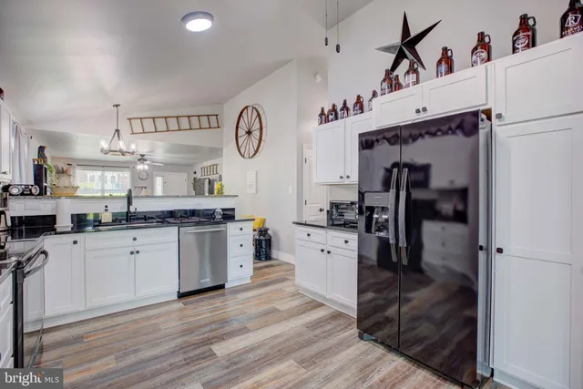 a kitchen with granite countertop a stove cabinets and wooden floor