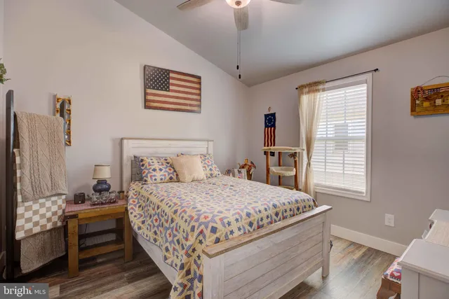 a bedroom with a bed wooden floor and window
