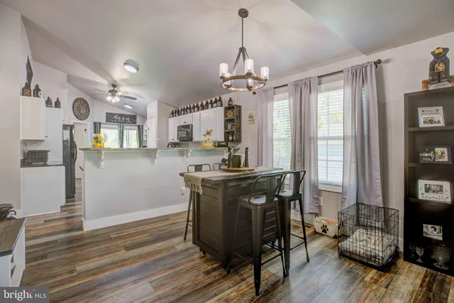 a view of a kitchen and dining table with granite countertop wooden floor