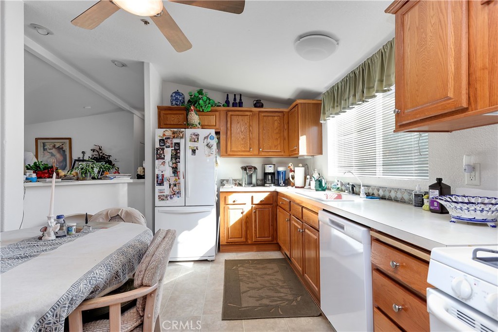 29520 Piani Road Pearblossom, CA 93553 - Photo 17 of 34 a kitchen with stainless steel appliances granite countertop a sink dishwasher stove and refrigerator with wooden cabinets