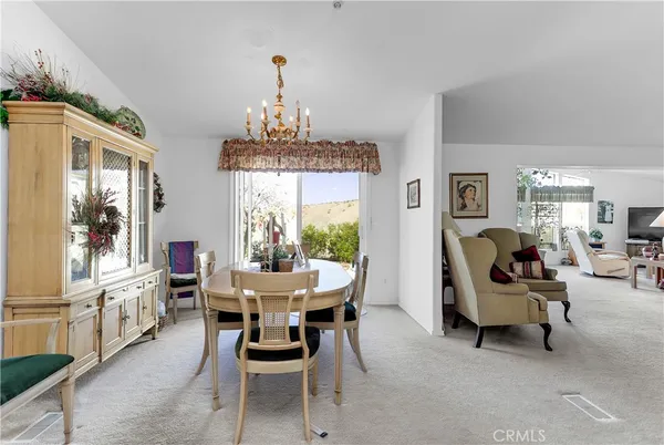 a view of a dining room with furniture and a chandelier