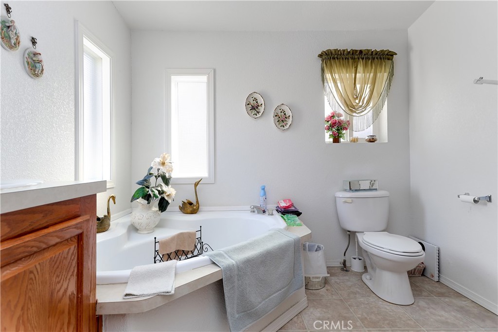 29520 Piani Road Pearblossom, CA 93553 - Photo 25 of 34 a white toilet sitting next to a bathroom sink and tub