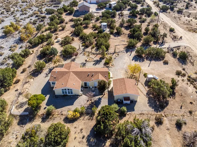 an aerial view of a house with a yard and mountain