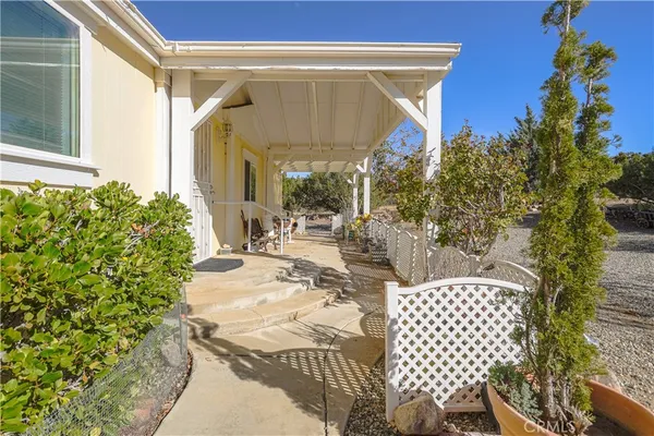 a view of two chairs and table in the patio