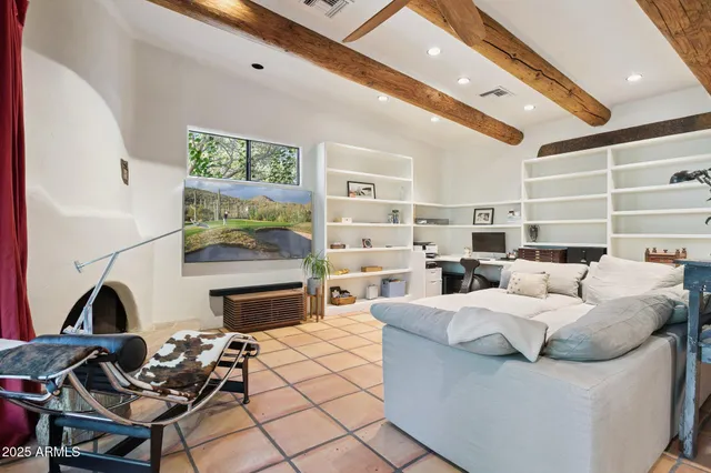 a living room with furniture fireplace and large windows