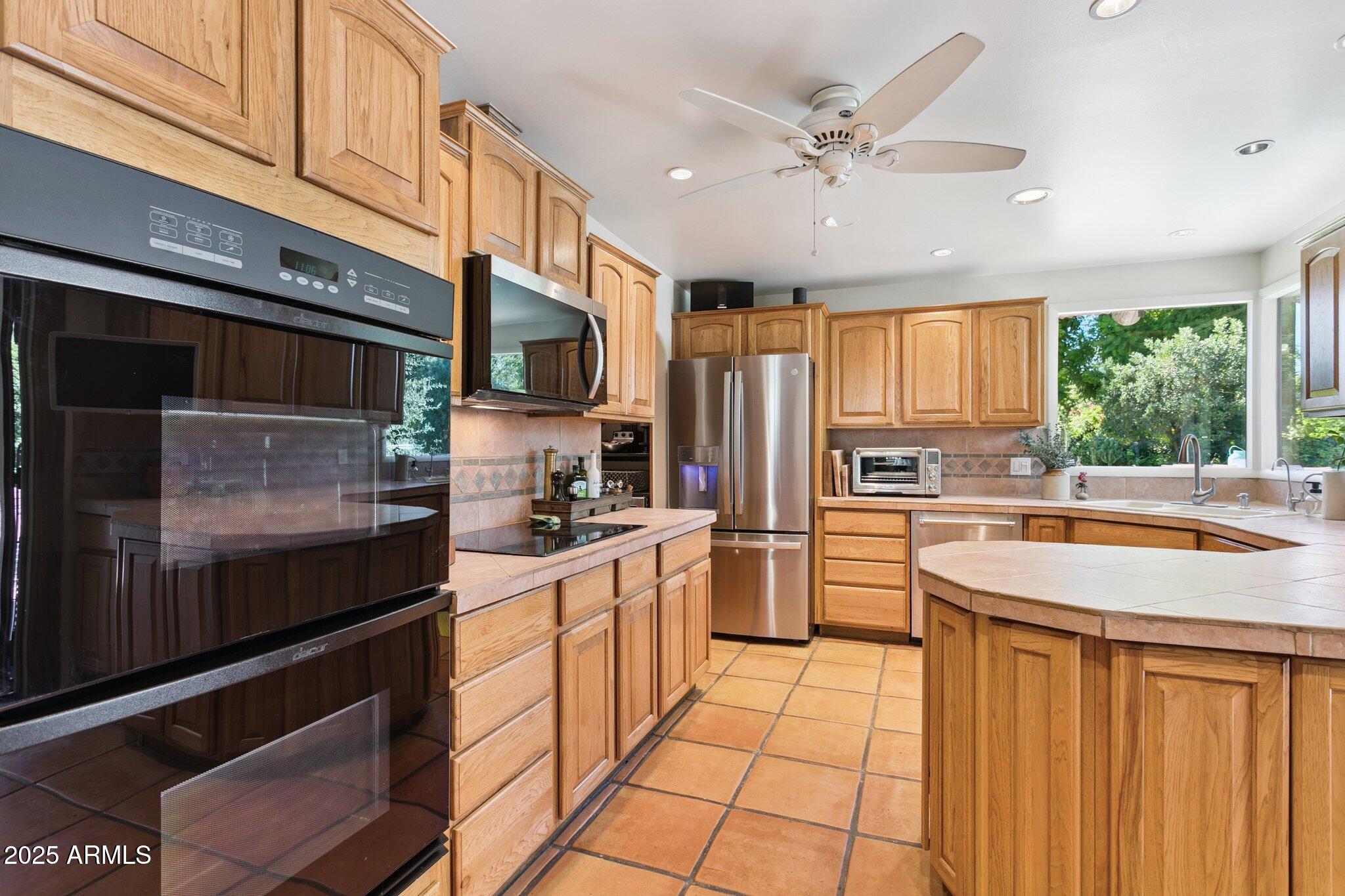 7005 East Jackrabbit Road Paradise Valley, AZ 85253 - Photo 16 of 61 a kitchen with stainless steel appliances granite countertop a sink stove and refrigerator