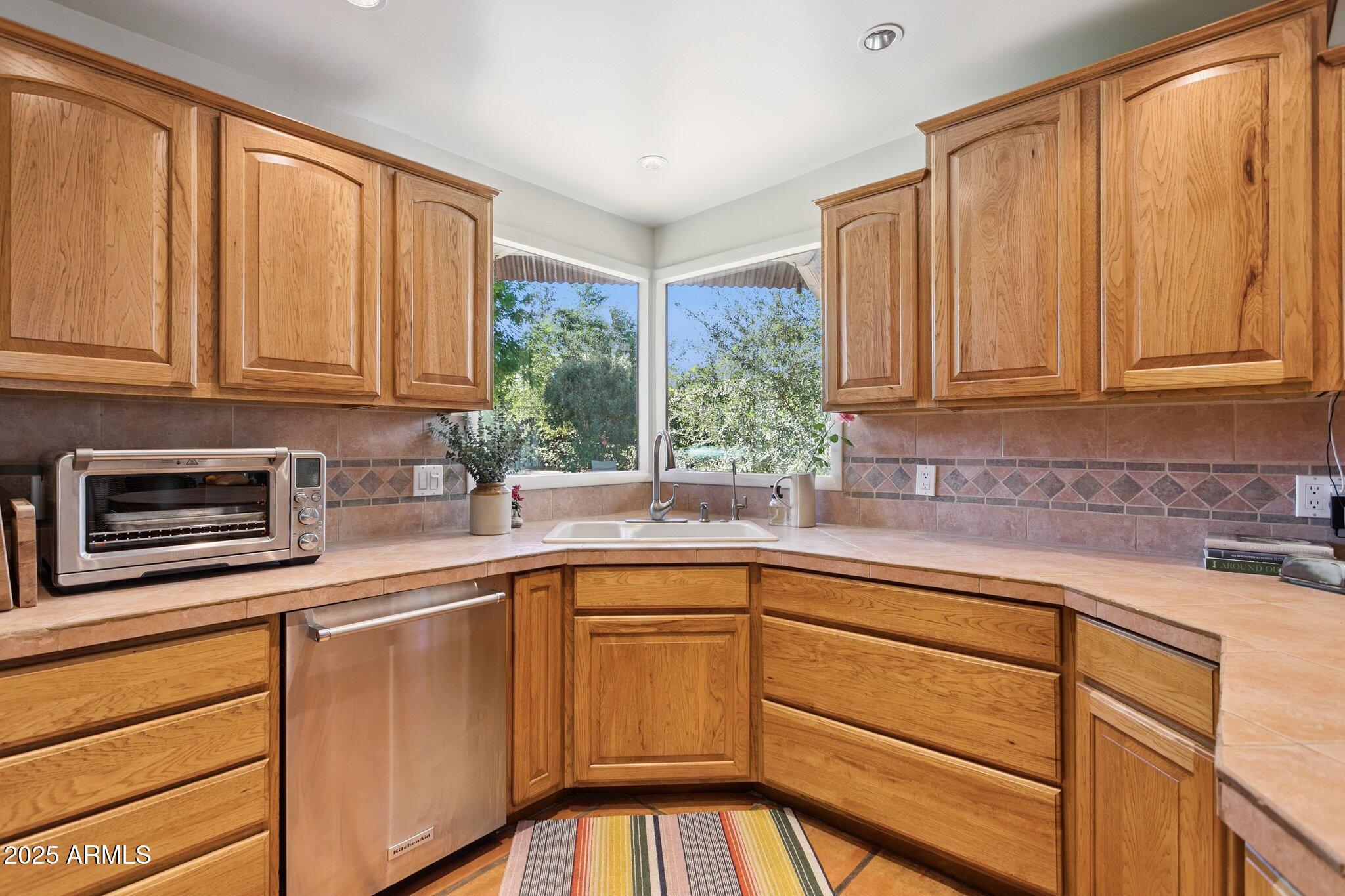 7005 East Jackrabbit Road Paradise Valley, AZ 85253 - Photo 18 of 61 a kitchen with stainless steel appliances granite countertop a sink stove and cabinets