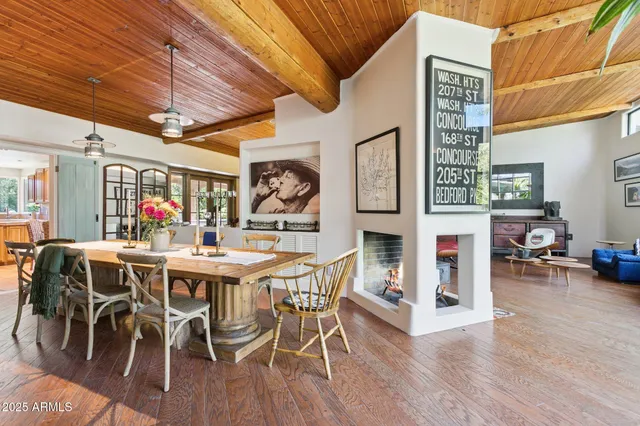 a dining room with wooden floor and chandelier